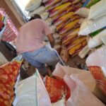 Salah satu pegawai CV.Srijaya saat memindahkan isi beras dari karung Raja Udang ke merk Satelit. Foto: Serunting.id