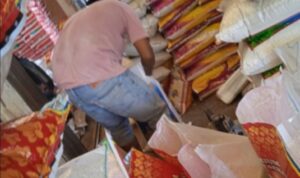 Salah satu pegawai CV.Srijaya saat memindahkan isi beras dari karung Raja Udang ke merk Satelit. Foto: Serunting.id